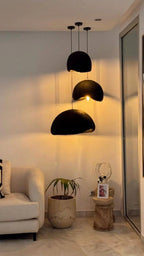 Trois suspensions CONCHA noires dans un salon